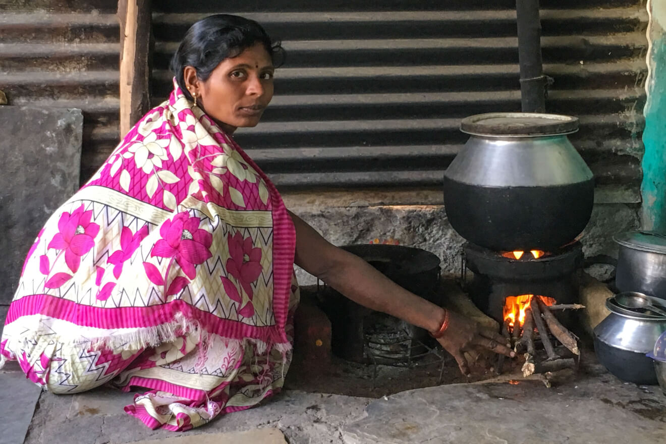 Eine indische Frau in Raichur an einem brennenden Kochofen