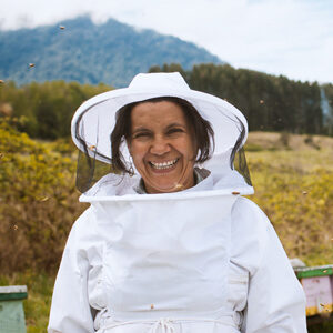 Smiling beekeeper from South America in beekeeper suit