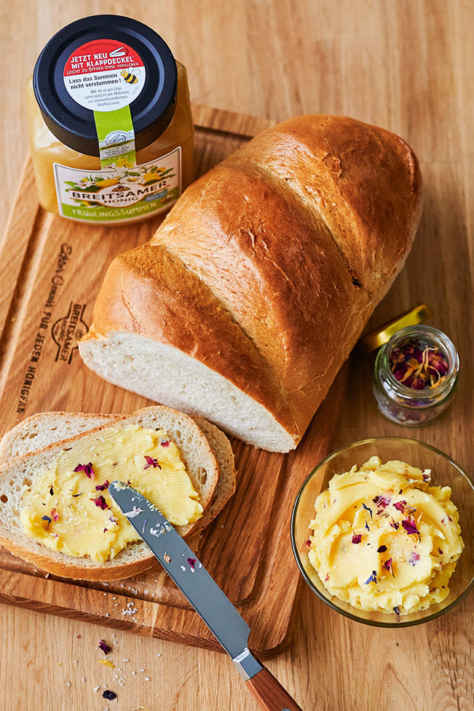 Wildblütenbutter mit Honig auf frischem Brot