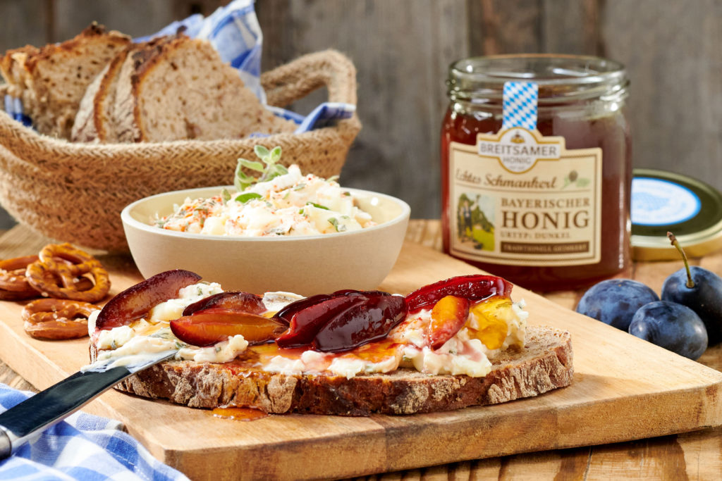 Brotzeitbrett mit Brotkorb, Gals Honig und Brot mit Käse und Honig