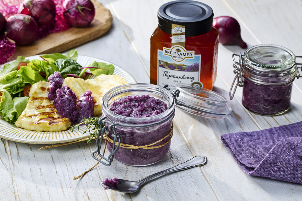 Honig-Zwiebel-Marmelade im Einmachglas, gefüllter Teller mit Salat, Käse und Marmelade und ein Glas Breitsamer Thymianhonig